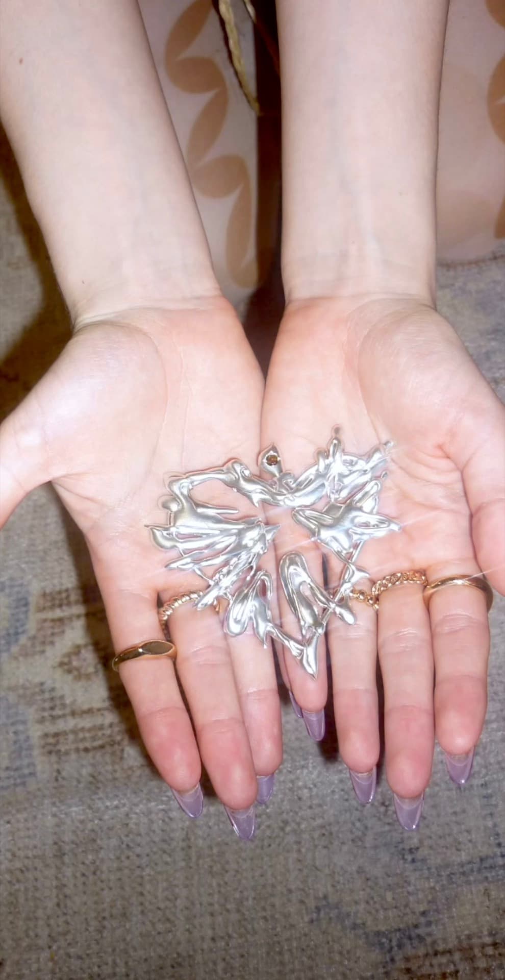 Hands holding a freshly cast silver piece